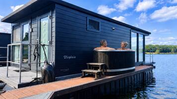 Una estructura flotante moderna con un jacuzzi y una pequeña terraza.