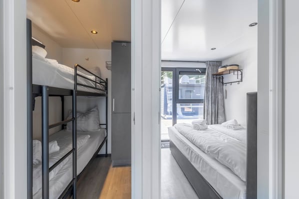 Una habitación de hotel con literas, un armario y una ventana con vistas al exterior.