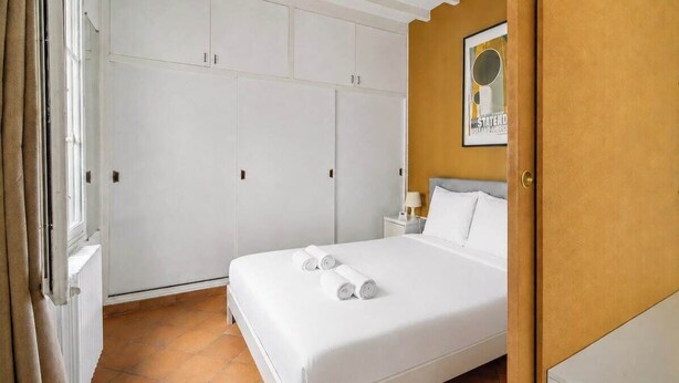 A bedroom with a bed, a wardrobe, and a nightstand. - Charming Fully Equipped 1BR - Near Paris (Boulogne-Billancourt)