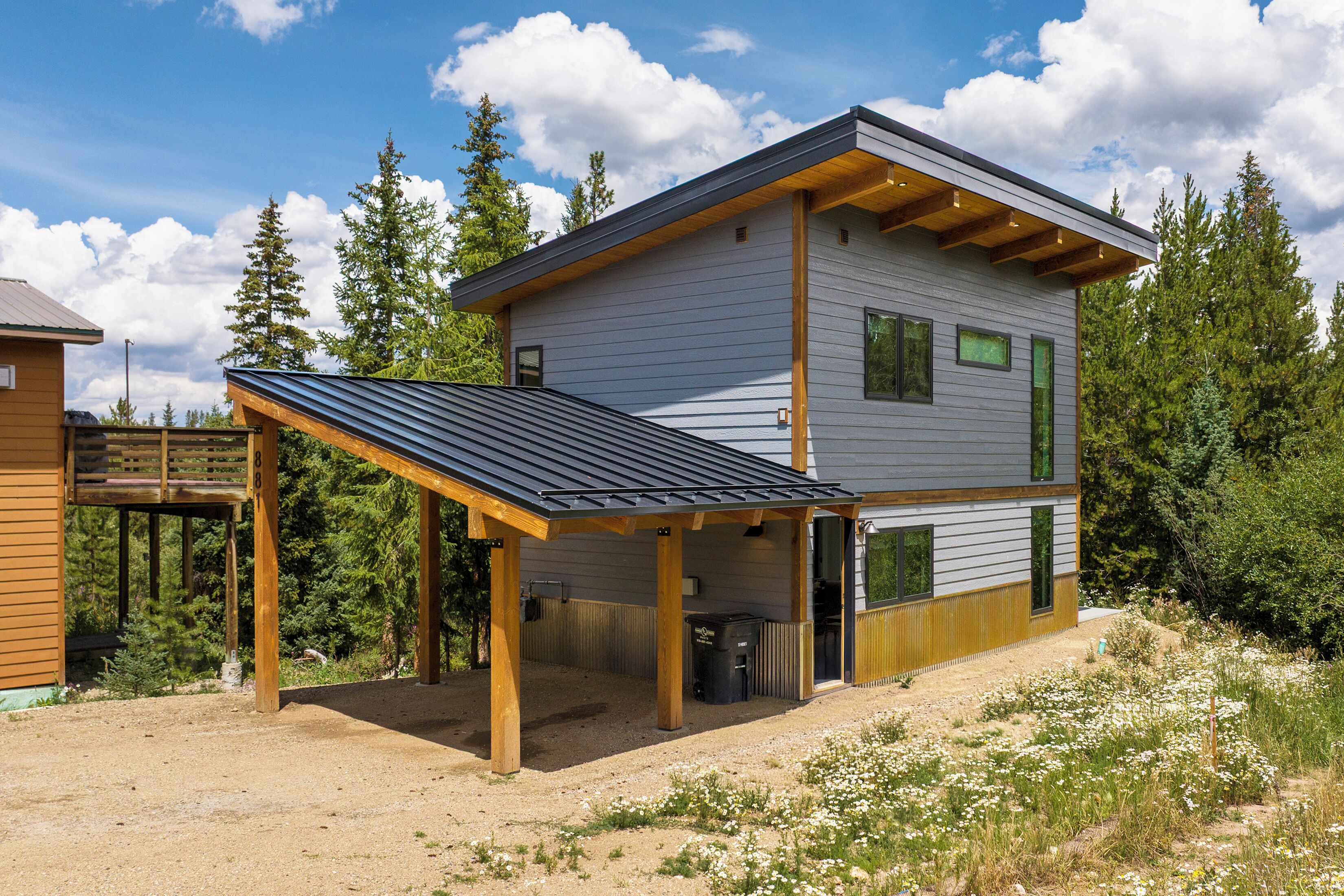 A two-story house with a covered patio, a garage, and a small attached shed.