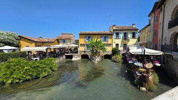 Un canal flanqueado por edificios, un puente y zonas de estar al aire libre.