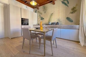 Eine moderne Küche mit Essbereich, ausgestattet mit Holzboden, Wandgemälde und Tisch mit Stühlen.
