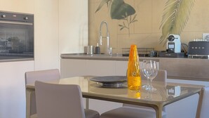 Una cucina moderna con zona pranzo, macchina del caffè e un vaso decorativo.