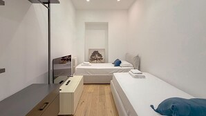 Una camera da letto moderna con un letto singolo, un comodino e una cassettiera.