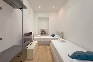 Ein modernes Schlafzimmer mit einem Einzelbett, einem Nachttisch und einer Kommode.