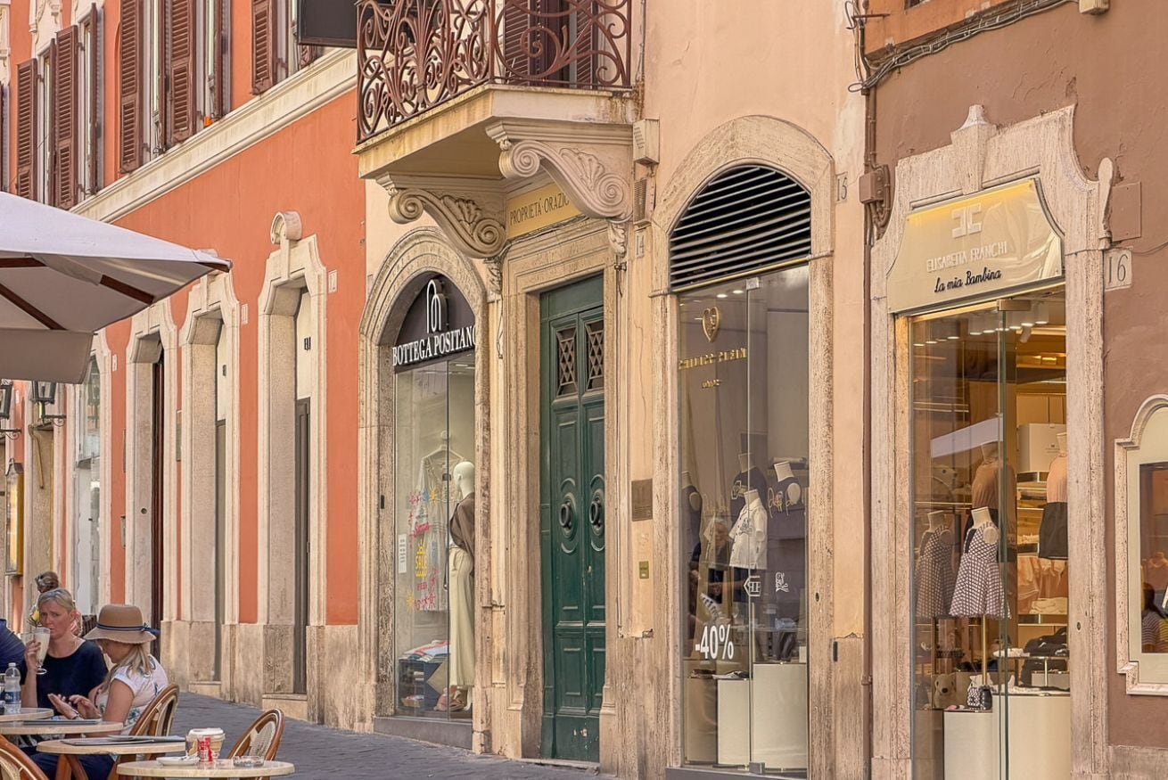 A street with shops, including a boutique and a bank.
