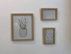 Drei gerahmte Kunstwerke an einer Wand.