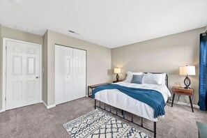 A bedroom with a bed, bedside tables, a nightstand, a rug, and a wardrobe. - Roadmap Lodging: Shadow Creek Retreat, 3BR Monthly, Pet OK (Columbus)
