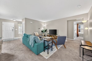 A living room with a sofa, a coffee table, a TV, and a chair. - Roadmap Lodging: Shadow Creek Retreat, 3BR Monthly, Pet OK (Columbus)