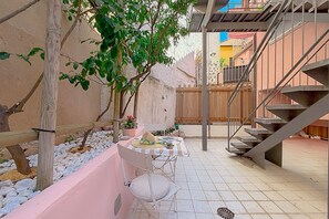 A patio with a table and chairs, a wooden fence, and a staircase. - In the Heart of Numana, 2 Bedrooms and A/C (Numana)