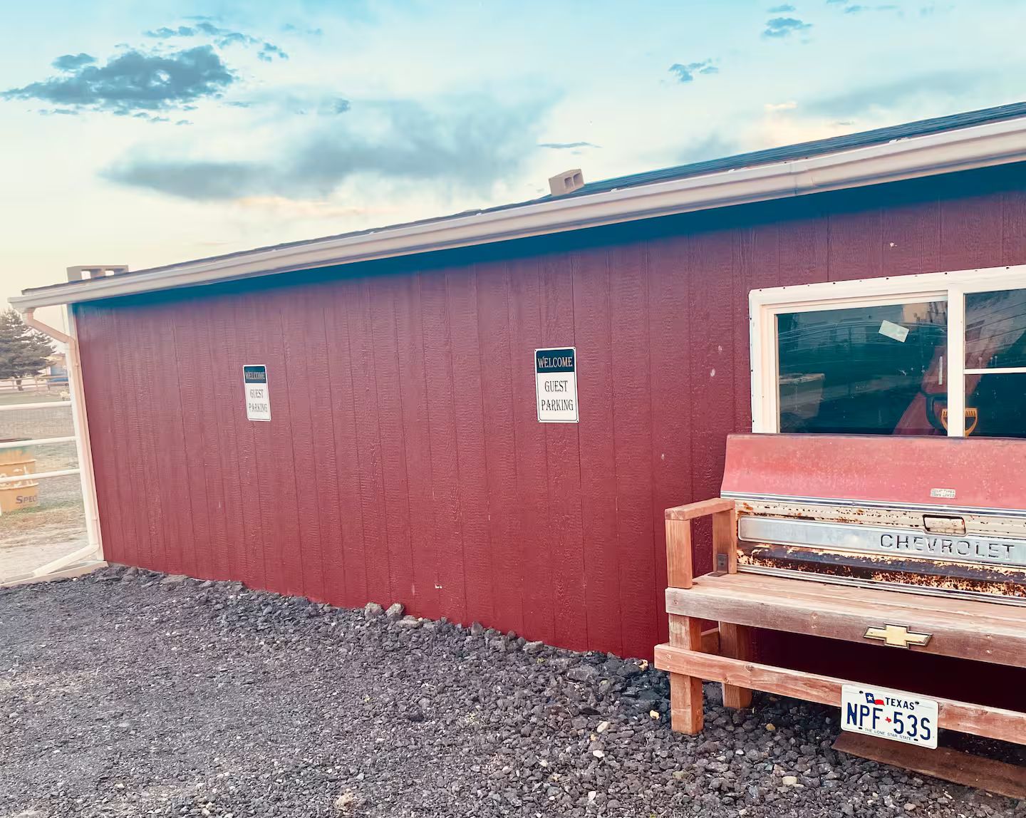 A red building with a sign indicating guest parking.