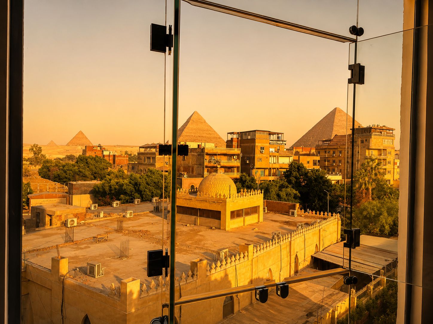 A view of the pyramids from a high-rise building with a glass facade.