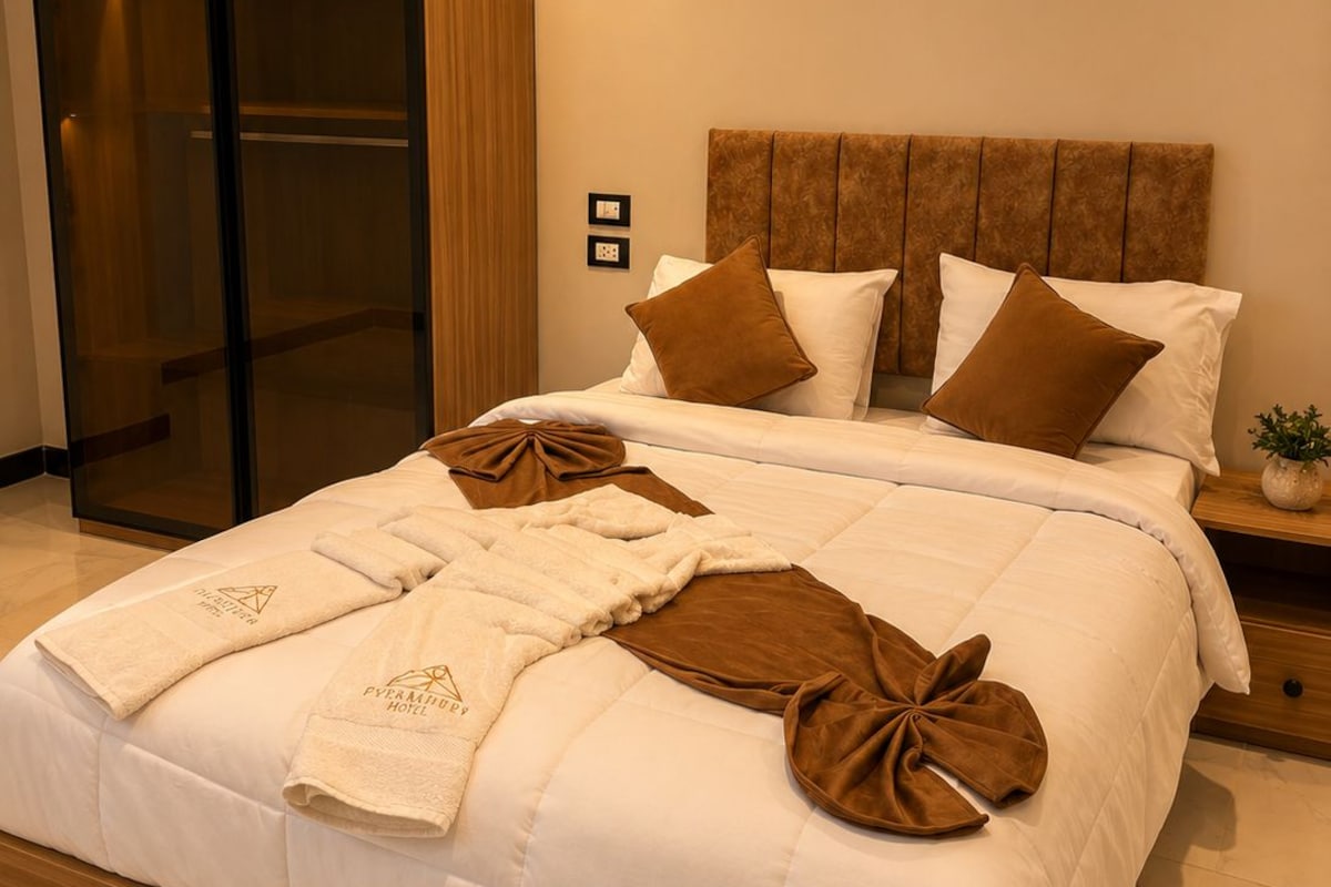 A hotel room with a bed, a wardrobe, and an air conditioning unit.