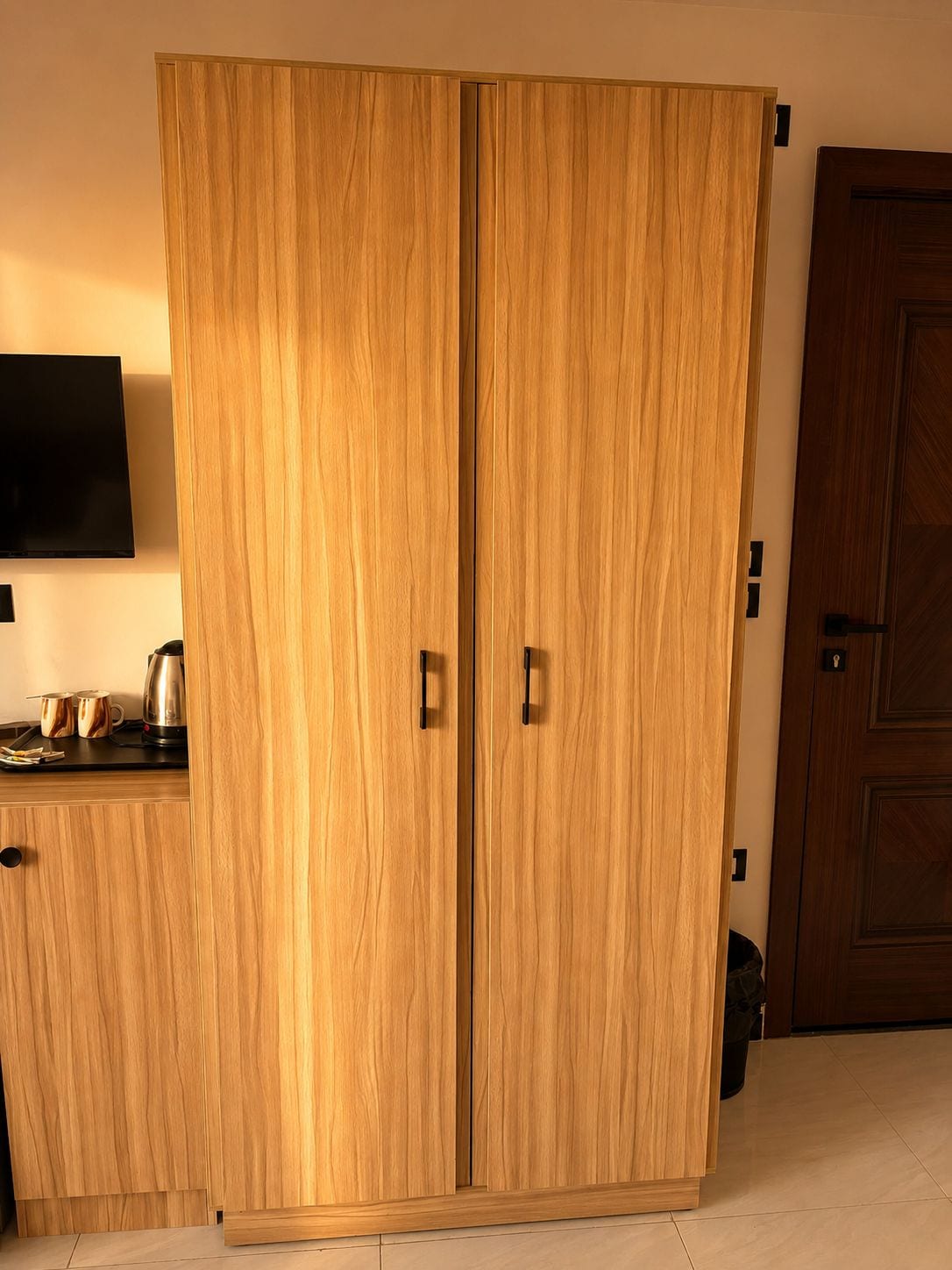 Un armario de madera con dos puertas y un pequeño aparador abajo.