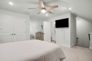A bedroom with a bed, a ceiling fan, a TV mounted on the wall, and a dresser. - New on Program! The Townes at Barefoot #5202! Your Favorite Place to Golf! (North Myrtle Beach)