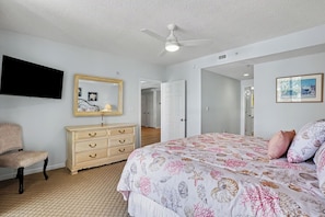 A bedroom with a bed, dresser, chair, and a ceiling fan. - New Property On Program! North Tower #207 in Barefoot Resort! (North Myrtle Beach)