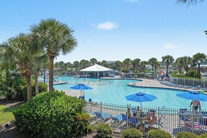 A pool area with multiple swimming pools, lounge chairs, and umbrellas. - New Property On Program! North Tower #207 in Barefoot Resort! (North Myrtle Beach)