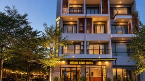 A multi-story hotel with a modern facade, large windows, and a well-lit entrance. - Hoang Linh Hotel Phu Quoc (Phu Quoc)