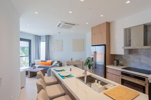 A modern kitchen with a built-in oven, a refrigerator, and a sink with a flexible faucet. - Modern Condo Near Eagle Beach-Balcony, Pool & Gym, Brand new Walishali Condo (Oranjestad)