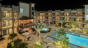 A hotel with a pool, outdoor seating, and a thatched-roof structure. - Modern Condo Near Eagle Beach-Balcony, Pool & Gym, Brand new Walishali Condo (Oranjestad)