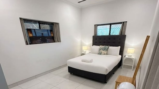 A modern bedroom with a bed, a ceiling fan, a window, and a nightstand. - Zen Hideout Studio Near Hospital Uni Study (Darwin)