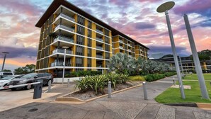 A multi-story building with balconies, a parking area, and a landscaped garden. - Zen Botanica Waterfront Sea View Pool Quiet (Darwin)