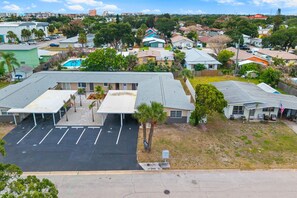 A residential area with a parking lot, houses, and a swimming pool. - Beachside Bungalow - Unit A | 2BR, 8-Min Walk to Beach, Patio & BBQ Grills 🌴 (Cape Canaveral)