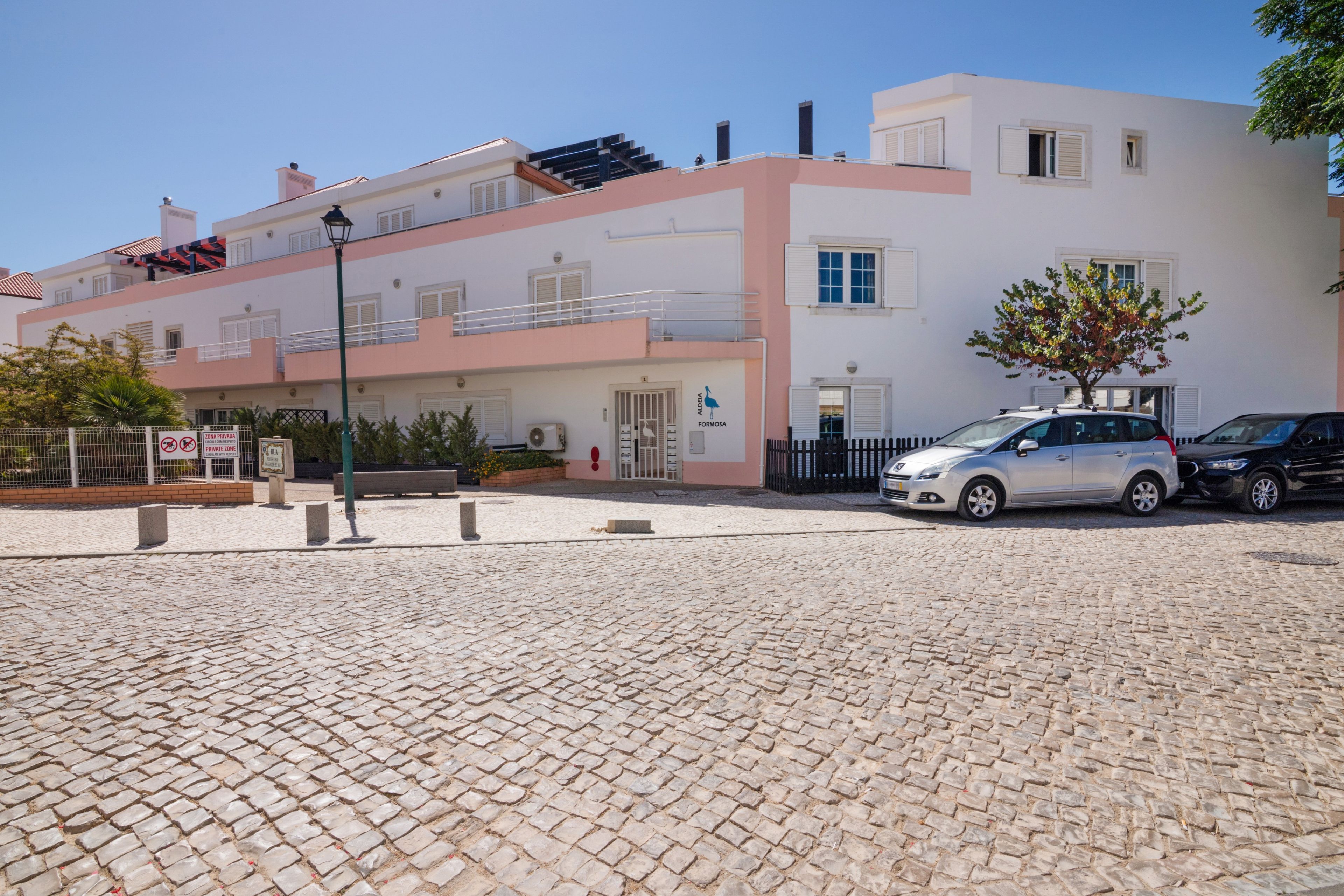 A building with a modern design, featuring a flat roof and a mix of balconies and windows.