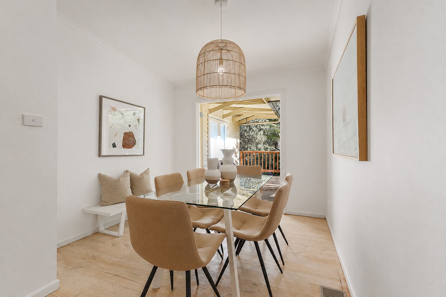 A dining area with a glass table, six chairs, and a hanging light fixture.