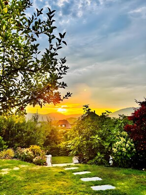 Ein Gartenweg führt zu einem Haus mit Blick auf die Berge.