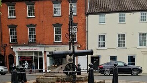 A street lamp with a cannon in front of a building with a sign for 'Harry's Coffee House'.