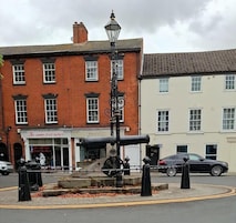 Un farol junto a un cañón frente a un edificio con un cartel que dice 'Harry's Coffee House'.