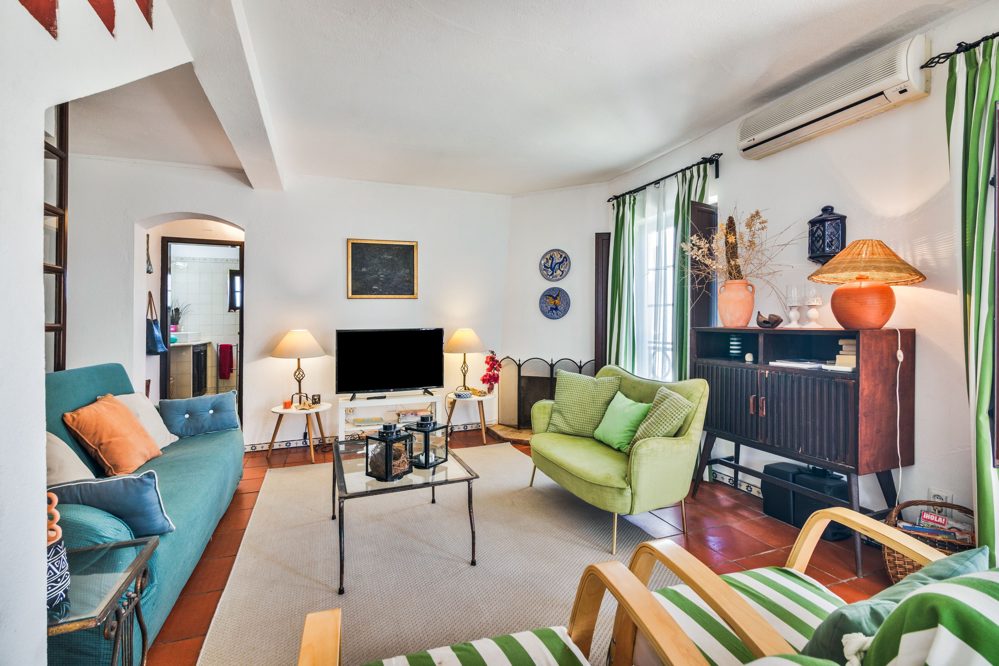 Una sala de estar con sofá, sillones, una mesa de centro, televisor y chimenea.