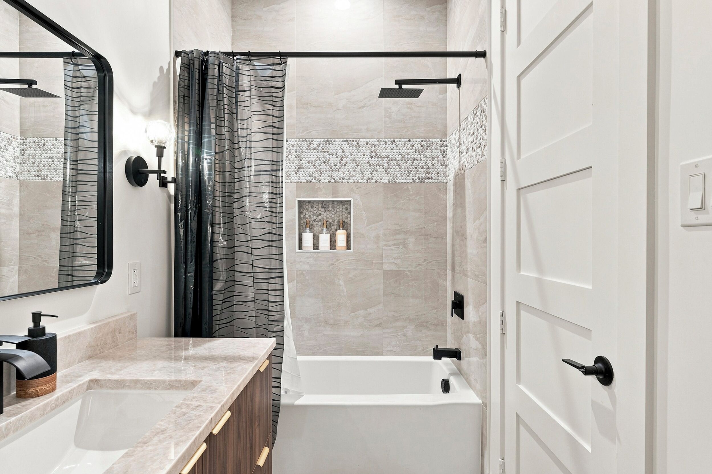 Un baño moderno con bañera, ducha y tocador con espejo.