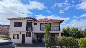 A two-story building with a tiled roof, balconies, and a gravel driveway. - Cabin near Villa de Leyva, Sachica, Boy (Sáchica)