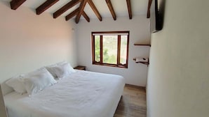 A bedroom with a bed, a window, and wooden beams on the ceiling. - Cabin near Villa de Leyva, Sachica, Boy (Sáchica)
