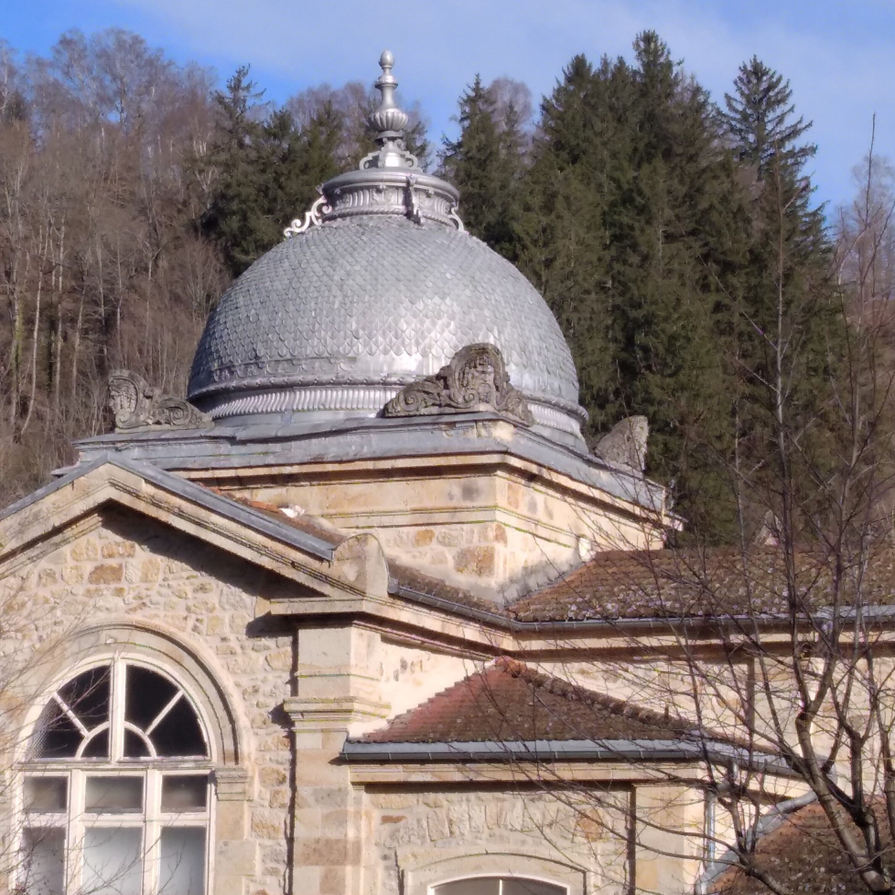 Un edificio de piedra con una cúpula grande y ventanas de arco.