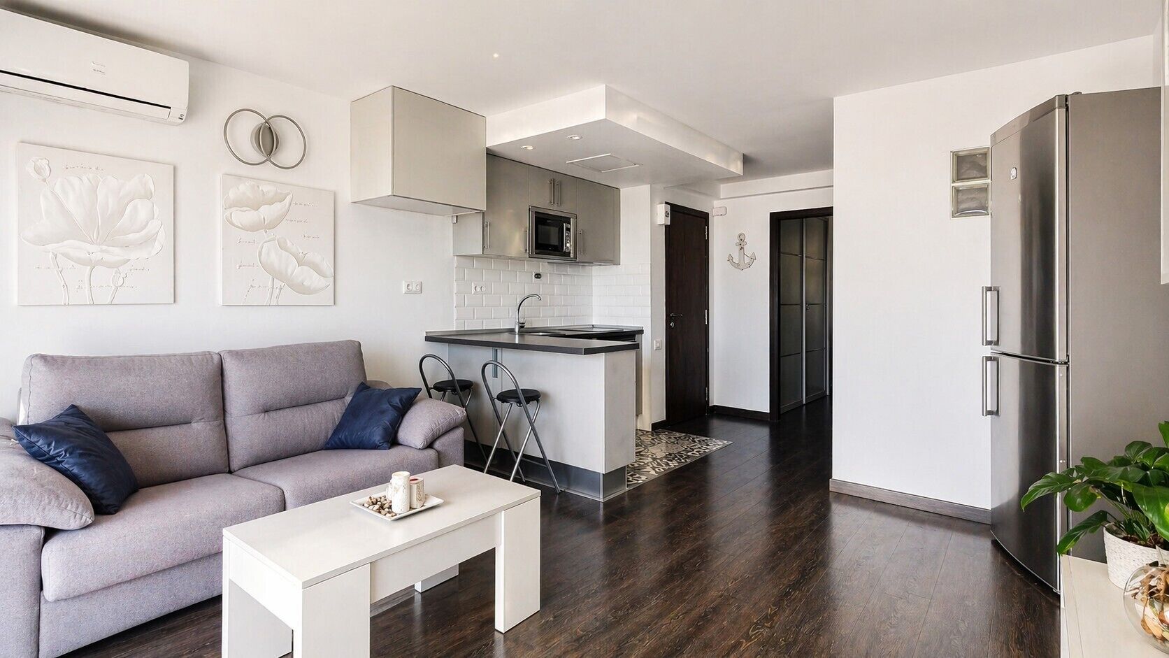A modern living room with a sofa, coffee table, and artwork on the wall.