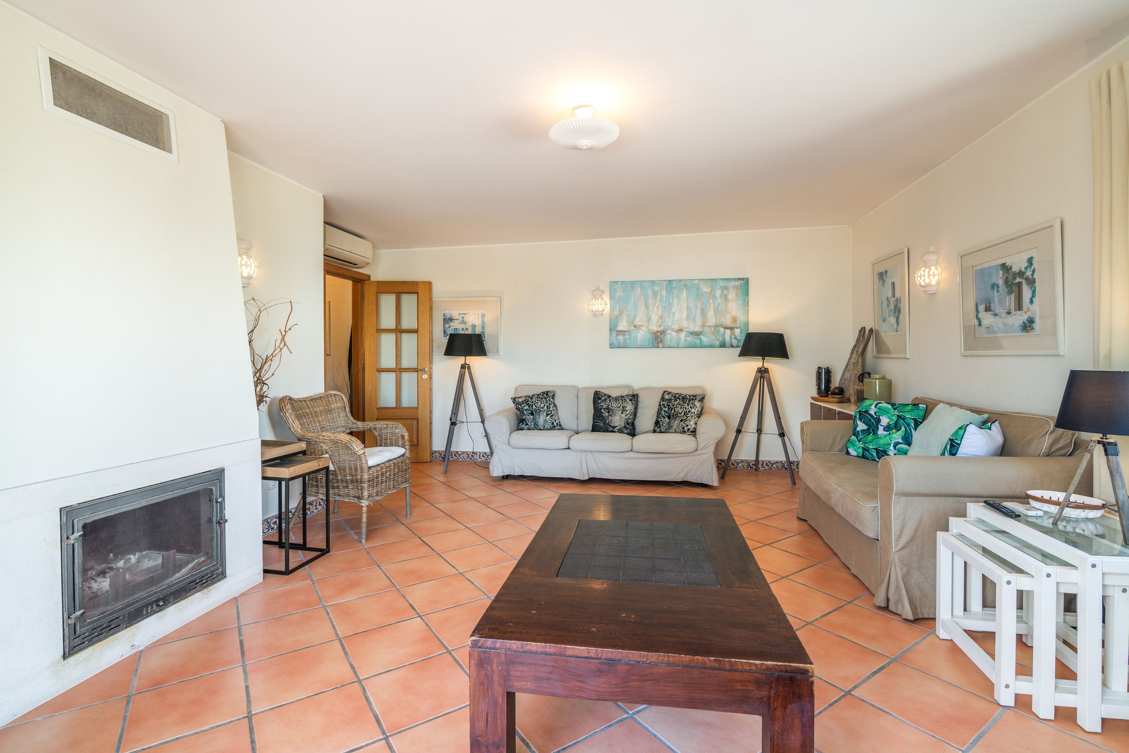 Una sala de estar con chimenea, un sofá, una mesa de centro y un cuadro en la pared.