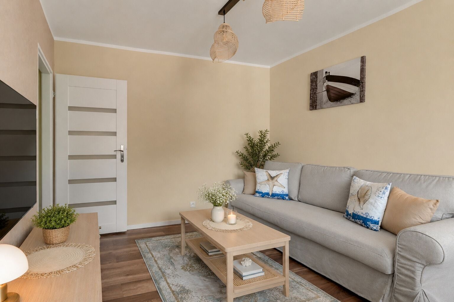 Un salon avec un canapé, une table basse, une lampe et une porte.