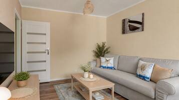 Un salon avec un canapé, une table basse, une lampe et une porte.