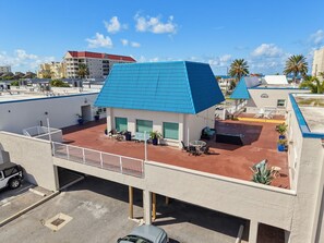 Un bâtiment doté d’un toit plat, d’un espace extérieur aménagé pour s’asseoir et d’un parking.