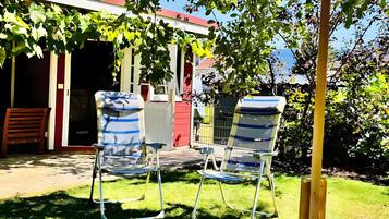 Eine Terrasse mit zwei Metallstühlen und einem Holzpfosten.