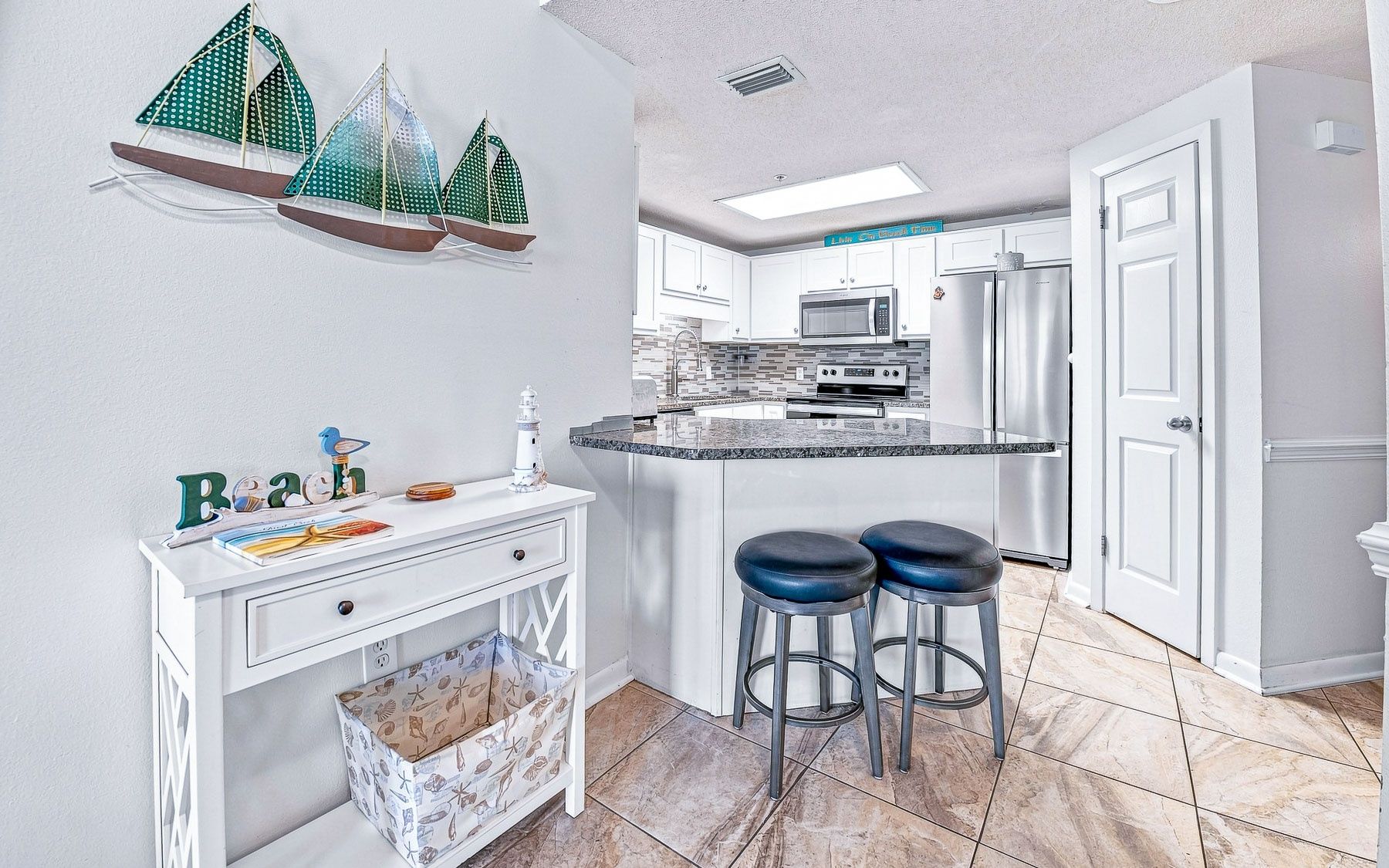 Une cuisine moderne avec un îlot central, des tabourets de bar et des éléments décoratifs.
