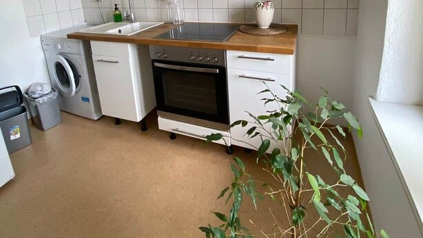 A compact kitchen with a built-in oven, a washing machine, and a sink. - Copy of To complete (Görlitz)