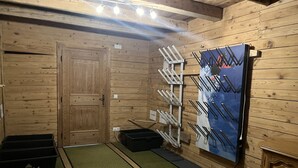 Ein Zimmer mit Holzboden, einer Tür, einem Wandregal und einer schwarzen Aufbewahrungsbox.