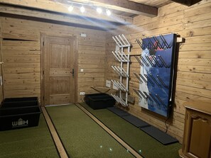 Ein Zimmer mit Holzboden, einer Tür, einem Wandregal und einer schwarzen Aufbewahrungsbox.