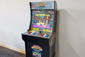 Ein alter Arcade-Automat mit Bildschirm, der ein Kampfspiel anzeigt, Joysticks und einem Münzeinslot.
