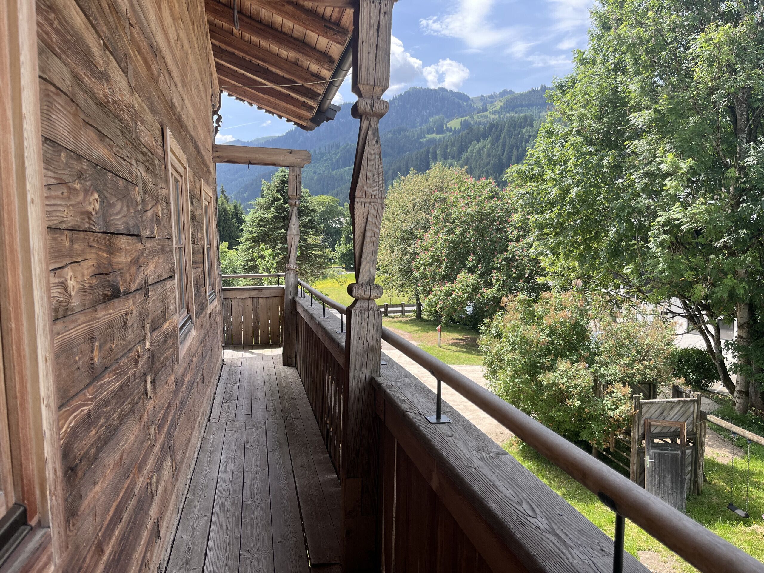 Un balcón de madera con vistas a un paisaje montañoso.