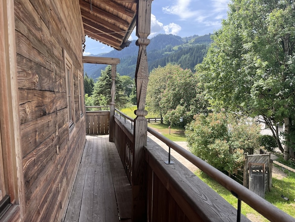 Ein Holzbalkon mit Blick auf eine gebirgige Landschaft.